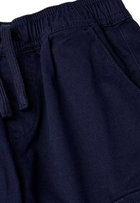 Marineblaue Shorts aus leichtem Stoff, mit einem elastischen Bund und Kordelzug, seitlichen Taschen und einer glatten Textur.