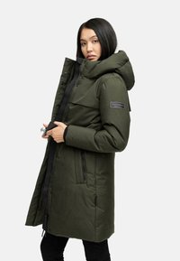 Oliven grøn parka-jakke med hætte, designet med en frontlynlås, trykknaplukninger og sidelommer. Har logo på ærmet.