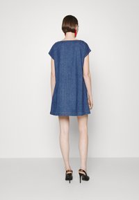 Jeansklänning med lös passform, kepsärmar och rund halsringning; har en något utsvängd form och subtil söm vid fållen.