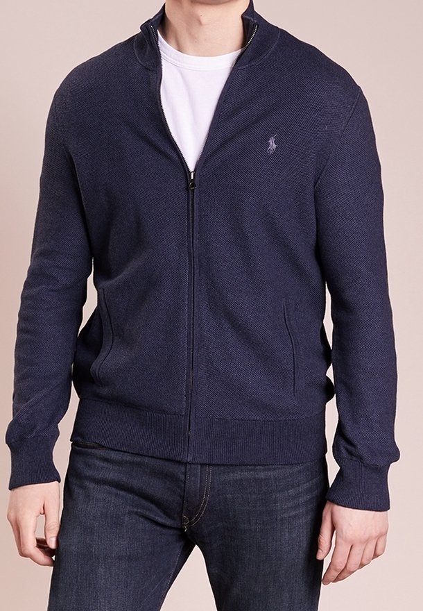 Marinblå zip-up sweater med en texturerad stickning, utrustad med hög krage, subtil logotyp på bröstet och två sidofickor.