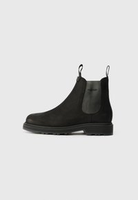 Bottines Chelsea noires en daim avec des panneaux latéraux élastiques, des languettes de traction, un bout arrondi et une semelle en caoutchouc robuste.