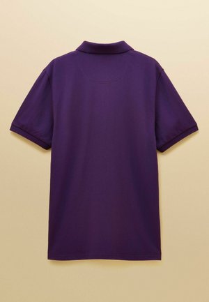 Lila Poloshirt mit kurzen Ärmeln, ausgestattet mit einem Kragen und einer glatten Stoffstruktur. Die Rückseite zeigt ein schlichtes Design ohne Verzierungen.