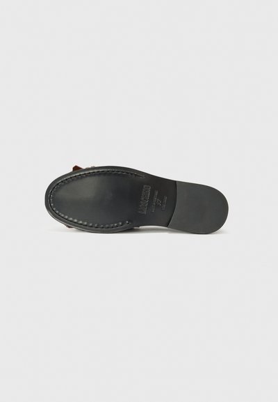 Black shoe sole with brown detailing, featuring stitched edges and brand inscription. Plain white background highlights the item.