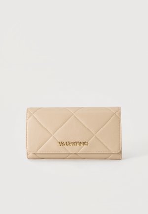 Portefeuille en cuir matelassé beige avec rabat pliant et logo Valentino doré sur le devant sur fond blanc uni.
