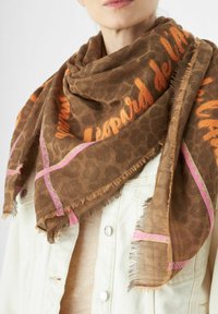 Sciarpa marrone con motivo a stampa leopardata, dotata di accenti rosa e bordi frangiati. Indossata in modo sciolto attorno al collo.