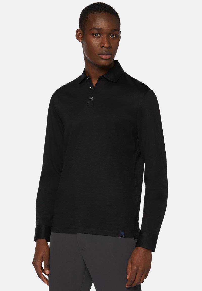 Czarna, długosleeve'owa koszulka polo z gładkiej bawełny. Posiada kołnierzyk, zapięcie na trzy guziki oraz subtelne logo na dolnym brzegu.