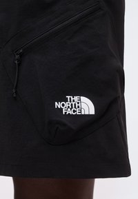 Μαύρα σορτς με τσέπη στο πλάι με φερμουάρ και το λογότυπο The North Face τυπωμένο με λευκό χρώμα στο κάτω μέρος του μηρού.