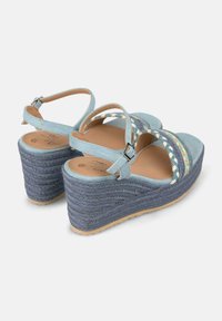 Sandali wedge blu con texture intrecciata, cinturini alla caviglia e dettagli intrecciati. Presentano un tacco rialzato e una suola testurizzata.