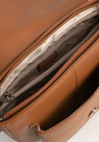 Borsa in pelle marrone con superficie texturizzata, dotata di un'apertura con zip e numerosi scomparti interni, inclusa una piccola tasca con zip.