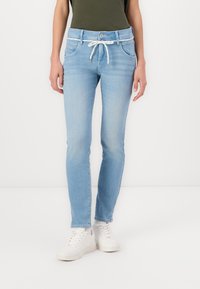 Jean en denim bleu clair avec une coupe droite, doté d'un cordon blanc, design à cinq poches et d'un léger délavage pour apporter de la texture.