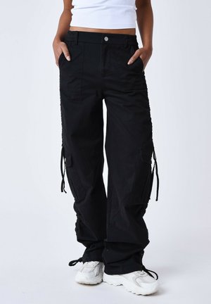 Pantalons cargo noirs avec une coupe décontractée, taille élastique, poches latérales, détails avec cordon de serrage et ourlets froncés. Fabriqués en tissu résistant.