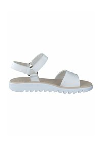White sandals with a textured upper, wide toe strap, and adjustable ankle straps. Features a flexible, ridged white sole for grip.