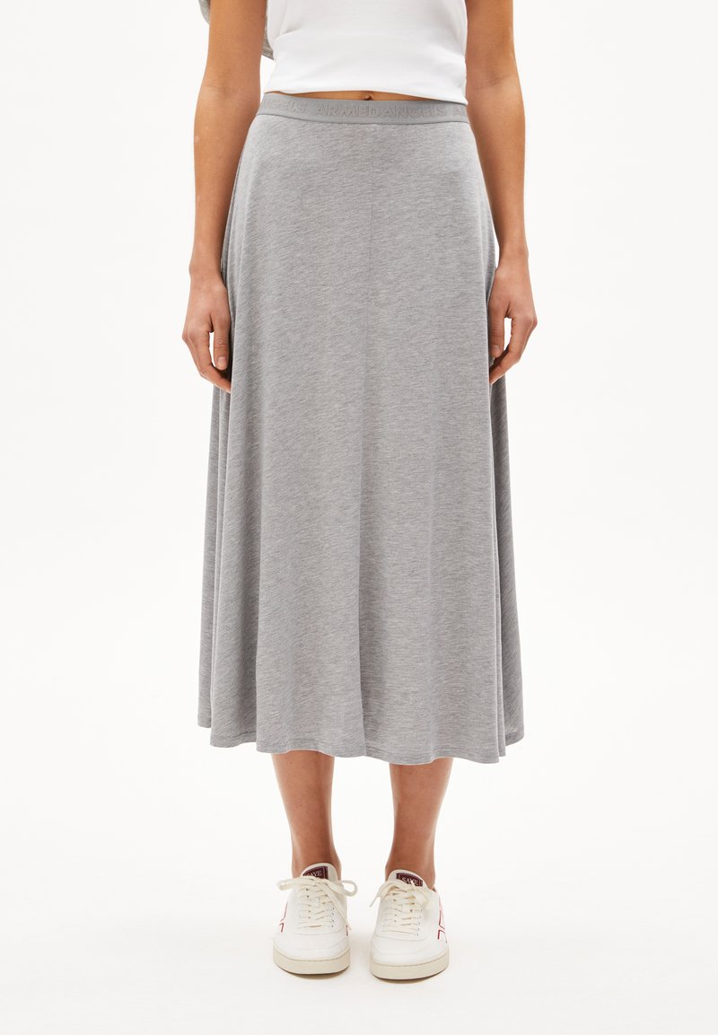 Gray, knee-length skirt made of soft fabric with a wide waistband featuring embossed text. Paired with white sneakers.
