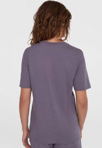 Kortærmet T-shirt i en dæmpet lilla farve, lavet af blødt stof med klassisk rund hals og afslappet pasform, med et mærke på siden.