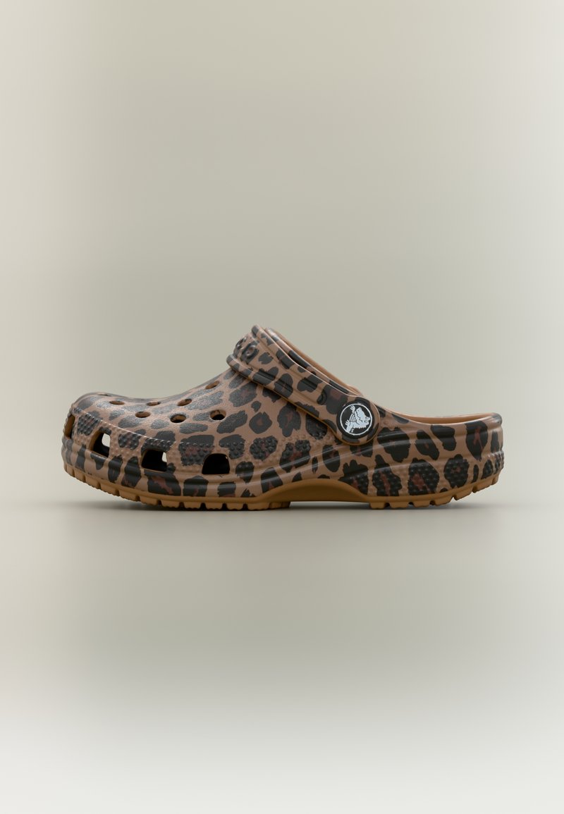 Καφέ σανδάλι τύπου κλογκ με μαύρες κηλίδες λεοπάρδαλης, οπές αερισμού και ρυθμιζόμενο λουράκι στη φτέρνα με κυκλικό λογότυπο.