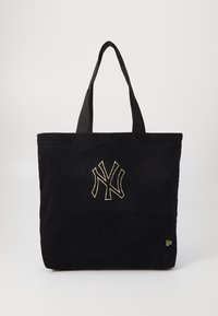 Μαύρη τσάντα tote από κόρντουρο με κεντημένο χρυσό λογότυπο, διαθέτει δύο υφασμάτινους ιμάντες και τετράγωνο σχήμα. Υφασμάτινη επιφάνεια χωρίς πρόσθετα σχέδια.
