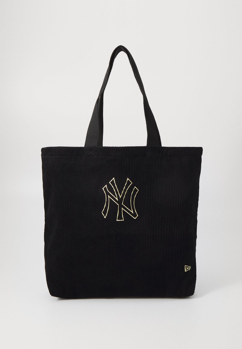 Μαύρη τσάντα tote από κόρντουρο με κεντημένο χρυσό λογότυπο, διαθέτει δύο υφασμάτινους ιμάντες και τετράγωνο σχήμα. Υφασμάτινη επιφάνεια χωρίς πρόσθετα σχέδια.