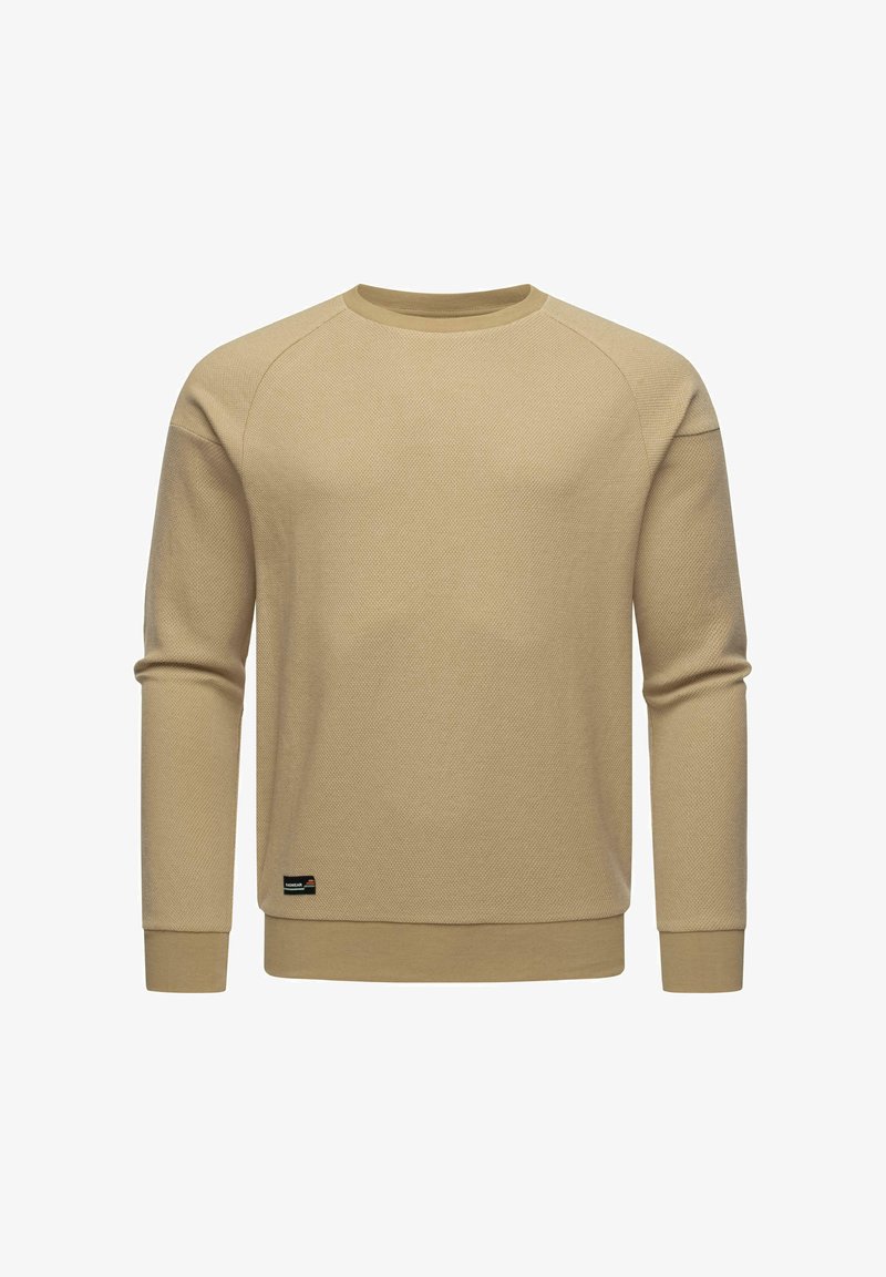 Sudadera beige de manga larga con tejido texturizado, puños acanalados y cuello redondo. Presenta un pequeño parche con el logo en el dobladillo.