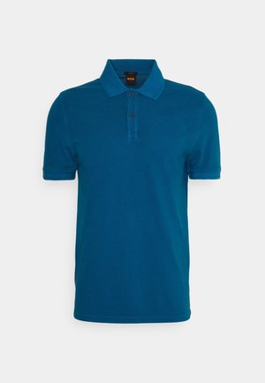 Polo bleu à manches courtes avec col, patte à deux boutons et logo de marque discret sur la poitrine sur fond uni.