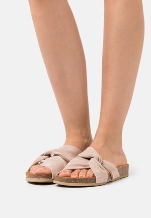 Lichtroze suède slide sandalen met een geknoopt ontwerp, platte kurken zool en open teen. Zachte textuur en een casual, minimalistische stijl.