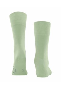 Calzini crew verde chiaro realizzati in un materiale morbido, con polsini a coste e cuciture piatte. Include dettagli stampati del marchio e della taglia sul lato.