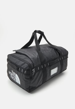 Sac de sport rectangulaire noir avec poignées doubles, poignées latérales, fermeture éclair et logo The North Face sur la poche avant.