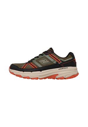 Chaussure de sport vert foncé et noire avec des accents orange et une semelle beige, fabriquée en Gore-Tex avec une semelle à motif robuste.