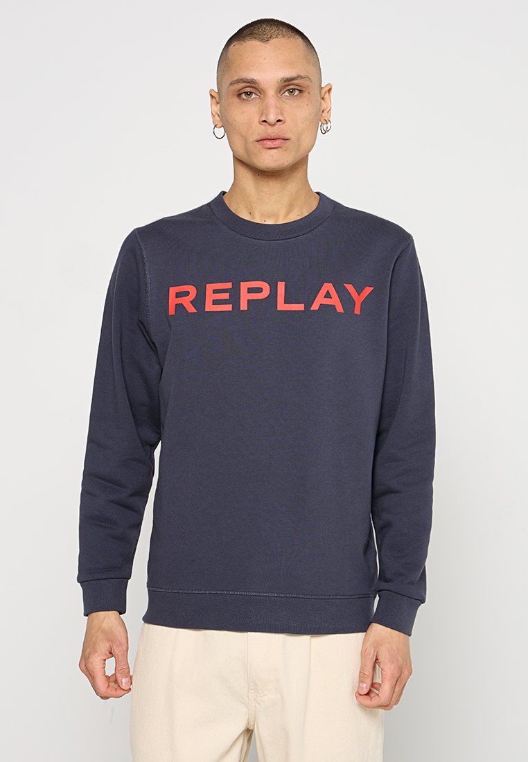 Marineblauwe crewneck sweatshirt gemaakt van zachte stof, met grote rode "REPLAY" tekst op de borst en ribgebreide boorden en onderkant.