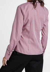 Camicia a quadri rossi e bianchi con maniche lunghe, vestibilità su misura, polsini abbottonati e sottili pieghe posteriori, realizzata in un tessuto leggero.