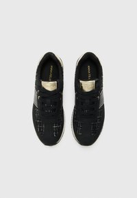 Black sneakers with textured fabric, smooth accents, round toe, lace-up design, and gold detailing on the tongue.
