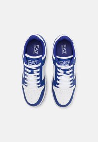 Blue and white sneakers with a perforated toe, laces, and contrasting design; features logos on the tongue and sides. Smooth synthetic material.