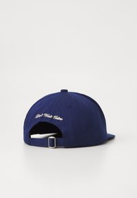 Sötétkék baseball sapka hímzett "Ne Pazarolj Kultúrát" felirattal, állítható pánttal a hátoldalon, sima szövettextúrával.