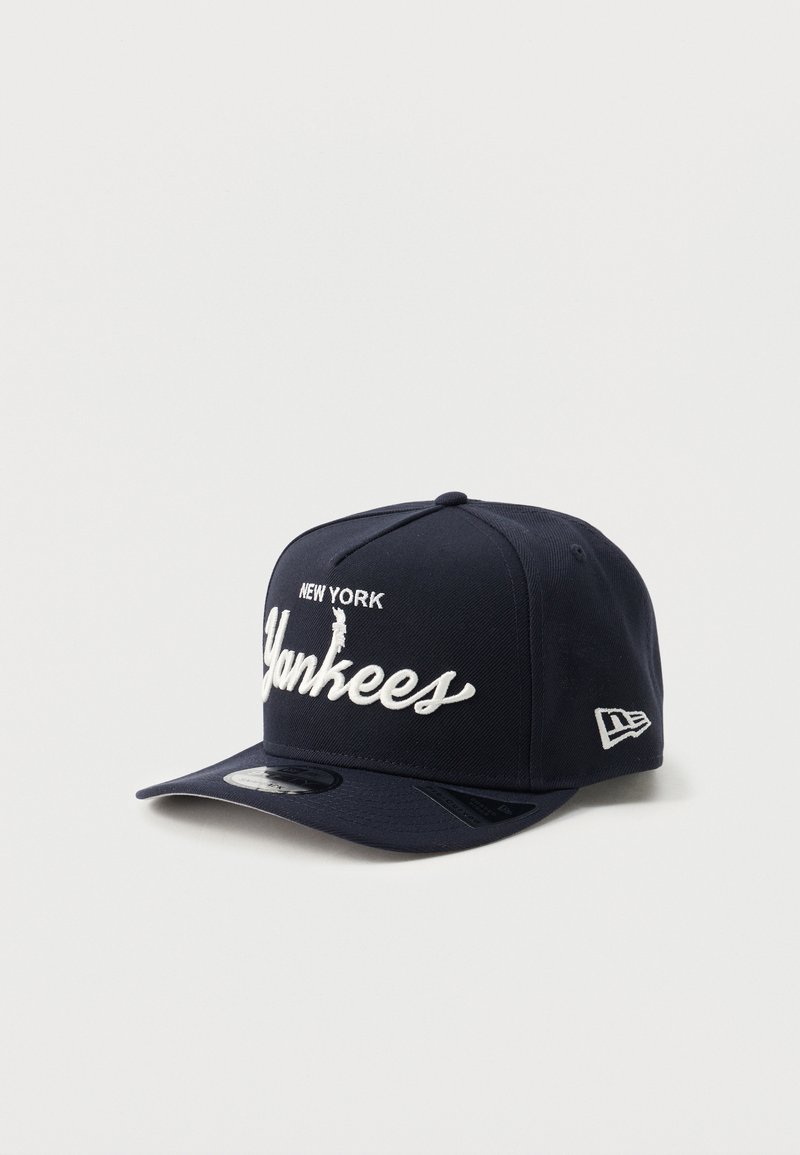 Casquette bleu marine en tissu structuré, avec "NEW YORK" et "Yankees" brodés en blanc. Visière courbée et logo sur le côté.