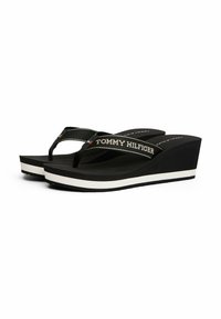Chanclas negras de cuña con correas texturizadas que presentan "TOMMY HILFIGER" en blanco, plantilla blanca y suela de goma para un buen agarre.