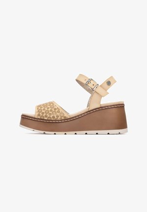 Sandalo zeppa in pelle beige traforata con cinturino alla caviglia, piattaforma marrone e suola in gomma bianca. Presenta una cucitura decorativa lungo il bordo.