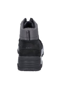 Svart och grå vandringskänga med en texturerad syntetisk överdel. Har en vadderad krage, kontrasterande vit mellansula och en kraftig yttersula.