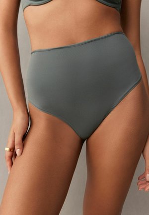 Bikini w wysokim stanem w stonowanej zieleni, gładki materiał z delikatną teksturą, z czystą talią i okrągłymi otworami na nogi.