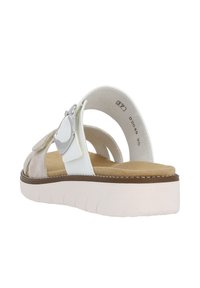 Open-toe sandals with a light beige suede upper, white straps, adjustable buckle, and a textured platform sole in light pink.