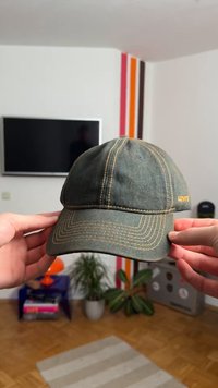 Green denim baseball cap with yellow stitching and Levi's logo on the side. Structured shape with a curved brim.