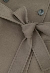 Bruine wollen jas met ceintuur, dubbelbreasted ontwerp met knoopsluiting en zachte textuur.