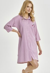 Różowo-biała koszula nocna w kratkę z kołnierzykiem, półdługimi rękawami, zapięciem na guziki i haftem czereśni na piersi.