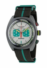 Zegarek chronograf z szarym stalowym korpusem, białą tarczą, turkusowymi sub-tarczami i czarnym tekstylnym paskiem z zielonymi przeszyciami.