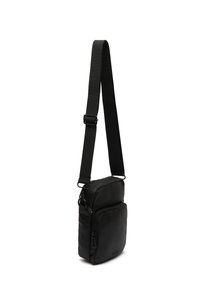 Svart crossbody-väska med en slät yta, två framdragkedjor och en justerbar rem. Designen är kompakt och rektangulär.