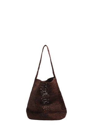 Bolso de hombro marrón tejido a ganchillo con un patrón de tejido abierto y una sola correa larga, de pie sobre un fondo blanco.