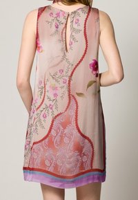Vestido sin mangas de tejido ligero con patrones florales y de paisley, en tonos cálidos de rosa y melocotón, y un detalle de corte con forma de ojo de llave en la espalda.
