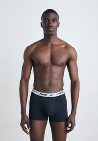 Čierne boxerky Nike sú vybavené bielym elastickým pásom s logom značky. Materiál vyzerá hladko a má priliehavý strih, pričom zachováva klasický štýl.