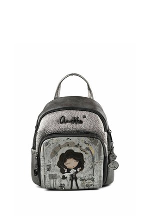 Piccolo zaino grigio metallizzato con un disegno di una ragazza dei cartoni animati con i capelli scuri che canta, circondata da note musicali e motivi decorativi.
