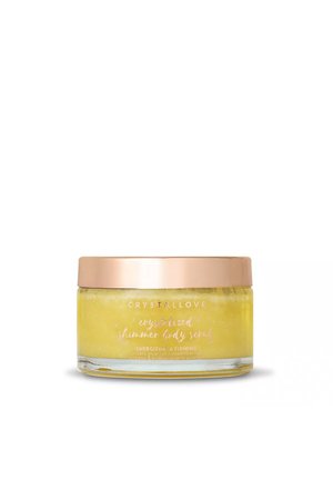 Szklany słoik z żółtym peelingiem do ciała oznaczonym "Crystallove crystallized shimmer body scrub" z różowo-złotą pokrywką na białym tle.