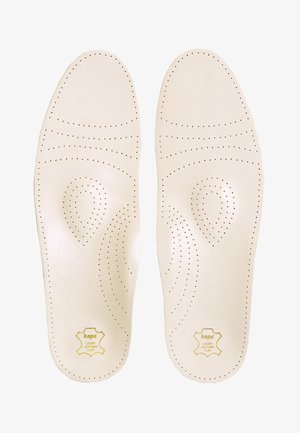 Kožené stielky v krémovej farbe s perforovanými vzormi pre priedušnosť. V pravom dolnom rohu sú vyrazené logo v žltej farbe.