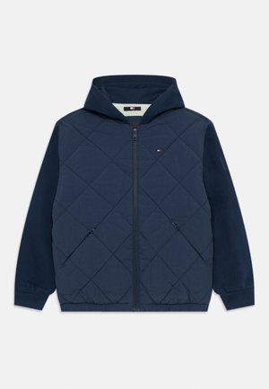 Navy quilted jacket with a hood, featuring a zip front, elastic cuffs, and side pockets. The body has a diamond pattern; sleeves are solid navy.